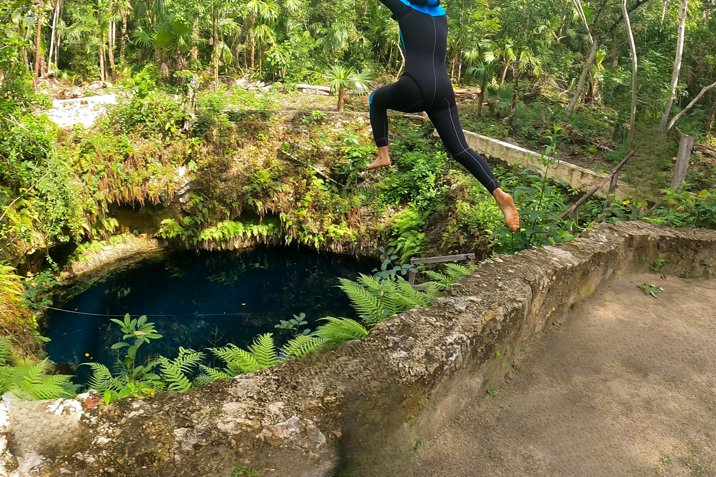 Personne sautant au-dessus d'un cenote en pleine nature, symbolisant l'audace, le lâcher-prise et le courage de se lancer dans l'inconnu. Sophrologue Nice, inspirant le bien-être.