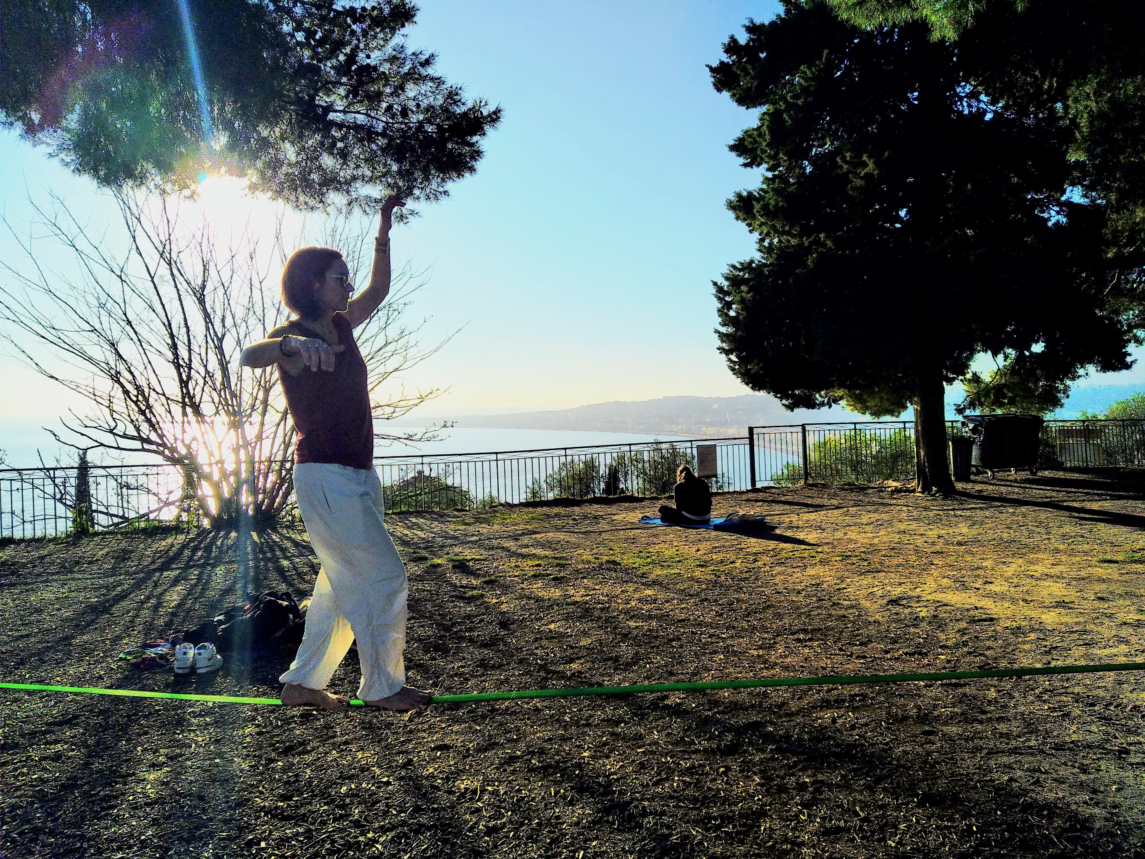 Personne en équilibre sur une slackline dans un parc, symbolisant le lâcher-prise, la concentration, la connexion au moment présent et le dépassement de soi à travers le challenge. Sophrologue Nice, inspirant le bien-être.