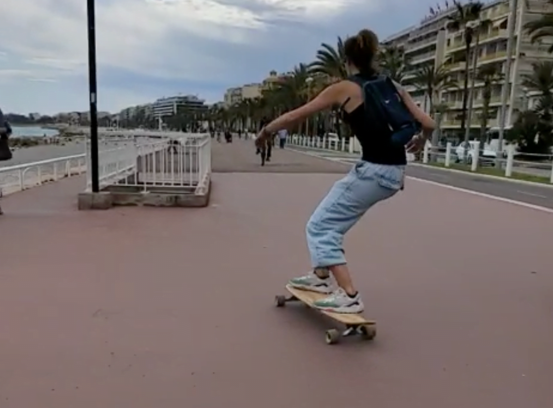 Personne en train de faire du longboard sur une promenade en bord de mer, incarnant le lâcher-prise, la confiance et l'amusement. Sophrologue Nice, inspirant le bien-être.