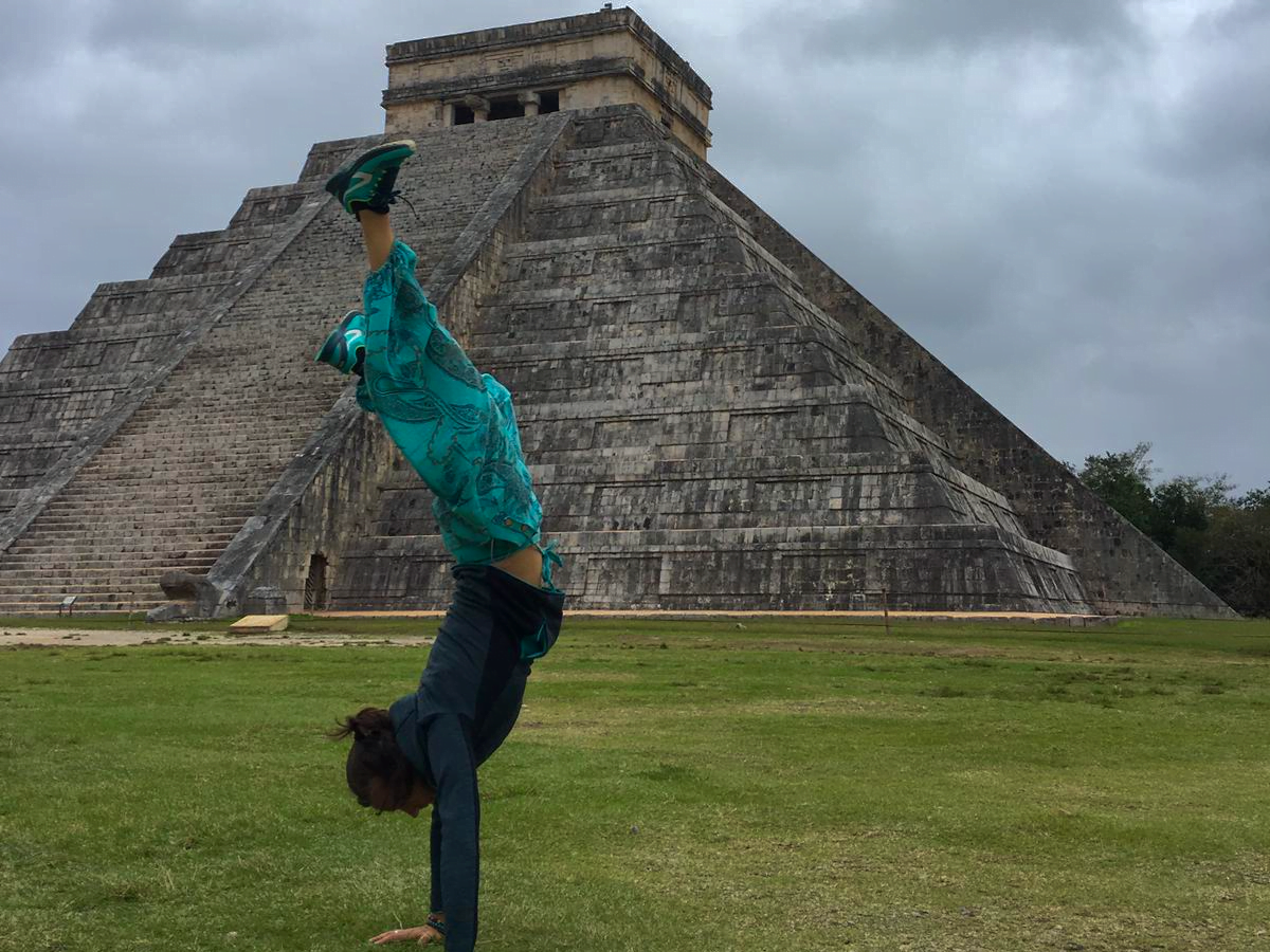 Personne faisant un arbre droit sur les mains devant une pyramide au Mexique, incarnant le lâcher-prise, le plaisir de profiter du moment présent et l'amusement. Sophrologue Nice, inspirant le bien-être.