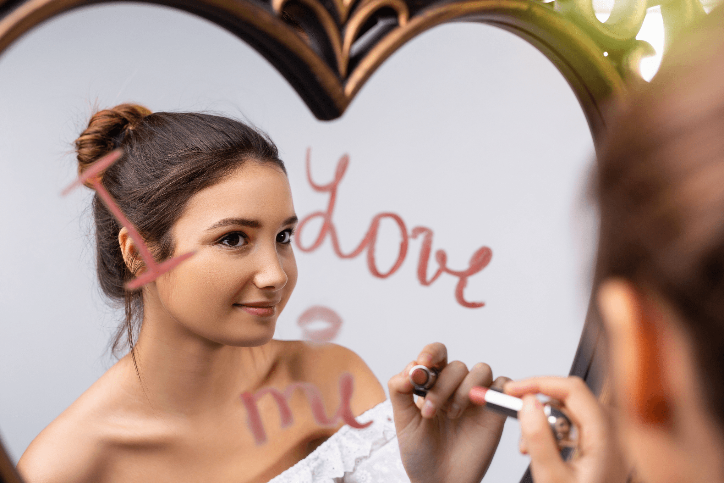 Une femme se regarde dans le miroir en écrivant "I love me" (je m’aime, en français), symbolisant la confiance en soi, l'amour propre et la connexion à soi-même, qui peuvent être obtenus grâce à la sophrologie.