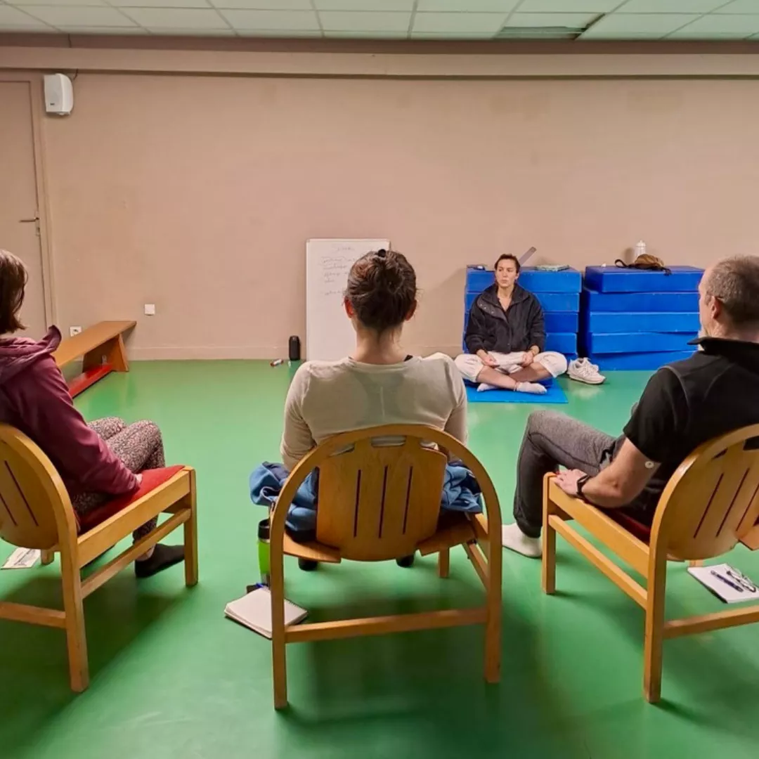 Aurélie Bousset accompagne des participants lors d'une séance de sophrologie guidée.